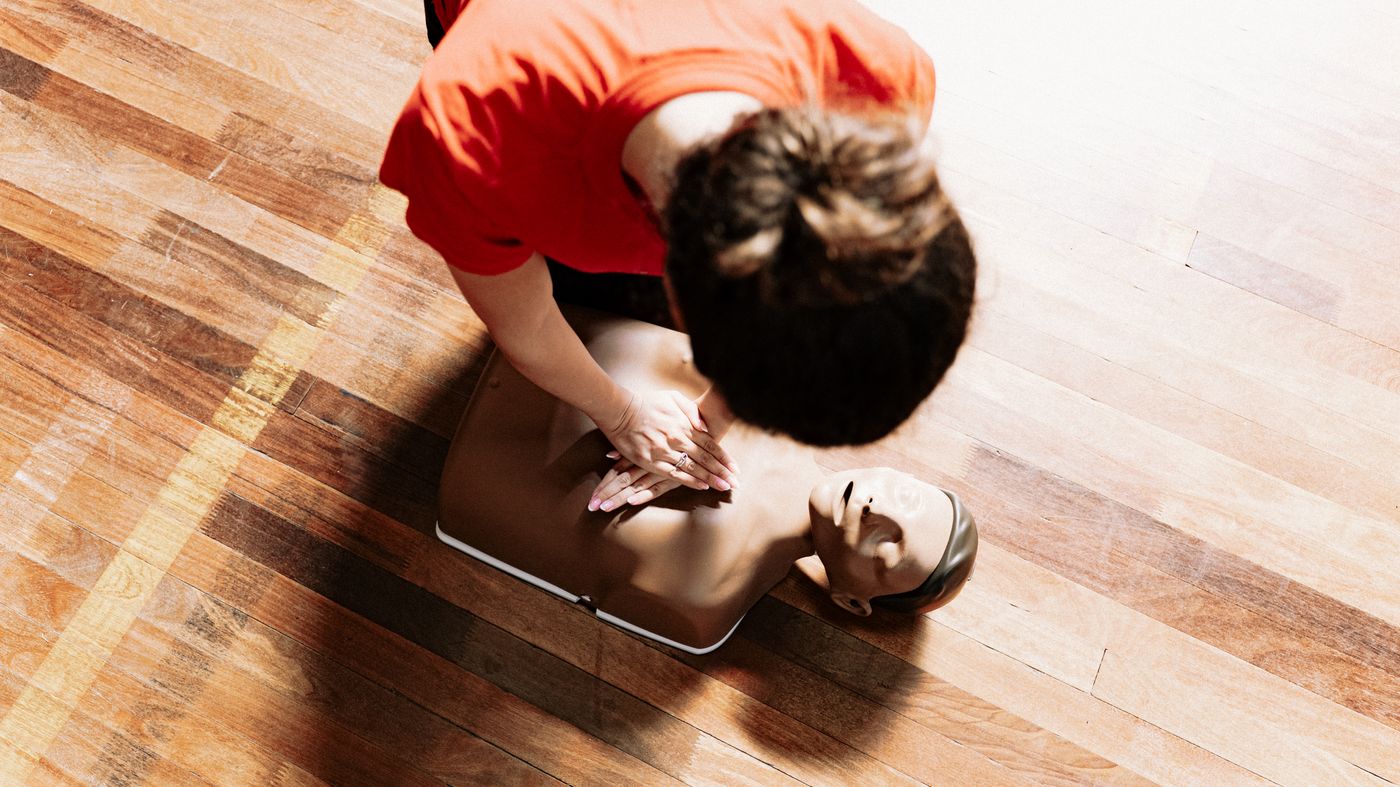 Instructor demonstrating CPR technique on a training mannequin