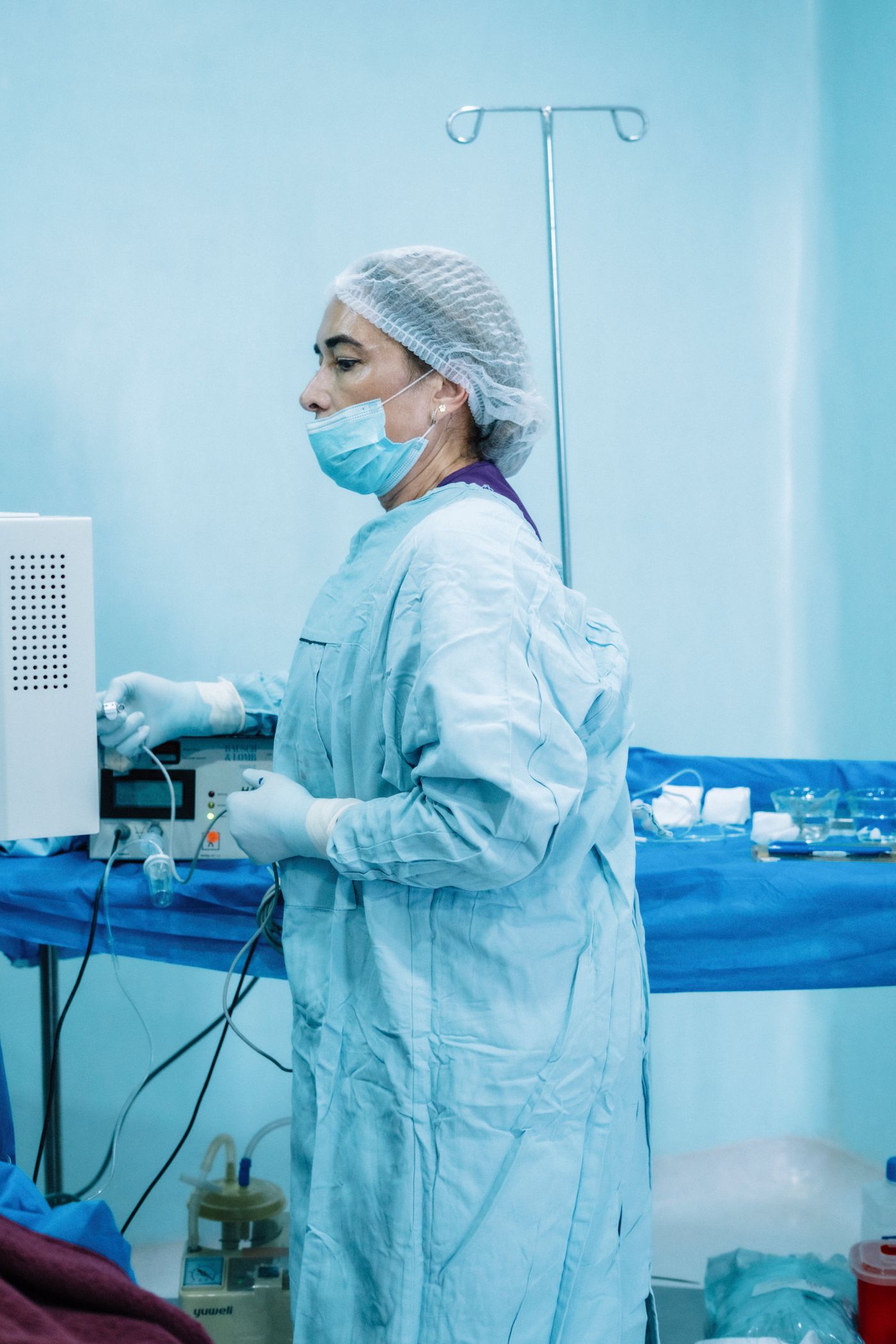 Clinician in sterile gown preparing equipment at a skills station